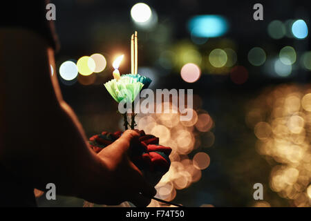 (151125) - BANGKOK, 26. November 2015 (Xinhua) - ein Mann soll seine Krathong zu schweben, während feiert das Loy Krathong Fest entlang des Chao Phraya River in Bangkok, Thailand, 25. November 2015. Zahlreiche Lotus-förmigen Flöße, geschmückt mit Kerzen, Räucherstäbchen und Blumen, von Thais als Krathongs, bekannt wurden auf Bangkoks Wasserflächen, wie der jährliche Loy Krathong Festival am Mittwochabend beobachtet wurde schwebte. (Xinhua/Li Mangmang) Stockfoto