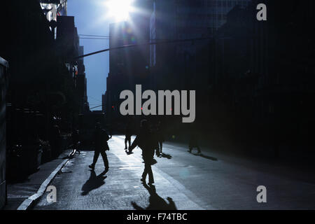 Blaue Schatten und Silhouetten von unkenntlich Menschen hinunter 34th Street in New York City bei Sonnenaufgang Stockfoto