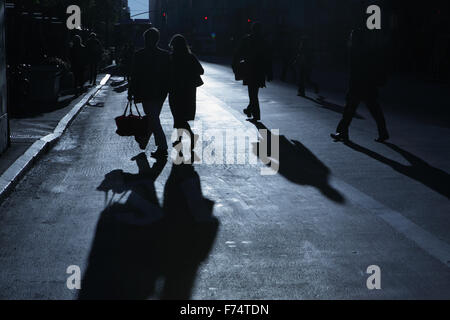 Blaue Schatten und Silhouetten von unkenntlich Menschen hinunter 34th Street in New York City bei Sonnenaufgang Stockfoto