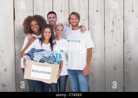 Zusammengesetztes Bild des Lächelns Gruppe von Freiwilligen halten Spendenbox Stockfoto