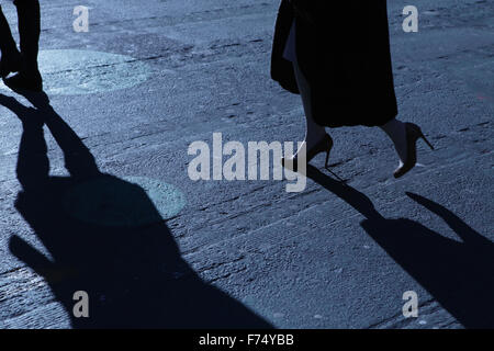 Blaue Nacht Schatten und Silhouetten von unkenntlich Mann und Frau auf einer Stadtstraße Stockfoto