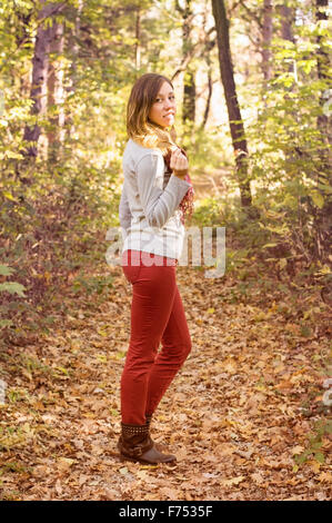 Schöne Brünette Mädchen im Wald mit einem herbstlichen Blatt in die Hände. Herbstliche Stimmung auf. Stockfoto