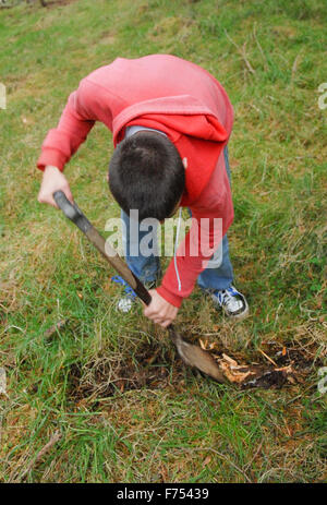 Teenager mit Schaufel Graben im Wald. Stockfoto