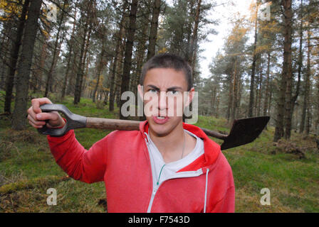 Teenager mit Schaufel Graben im Wald. Stockfoto