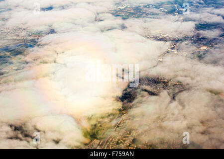 Ein Flugzeug wirft ein Gespenst gebrochen (ein Schatten des Objekts durch einen kreisförmigen Regenbogen umgeben) auf Wolke als es startet vom Flughafen Manchester entfernt. Stockfoto