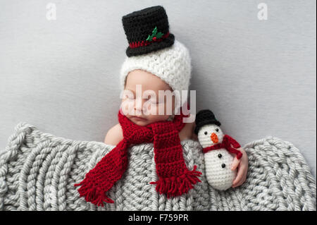 Neugeborenes Baby-junge trägt einen Schneemann Motorhaube und rotem Schal. Stockfoto