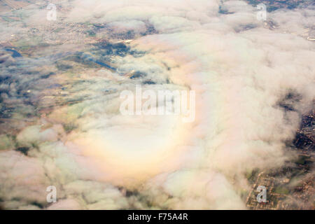 Ein Flugzeug wirft ein Gespenst gebrochen (ein Schatten des Objekts durch einen kreisförmigen Regenbogen umgeben) auf Wolke als es startet vom Flughafen Manchester entfernt. Stockfoto