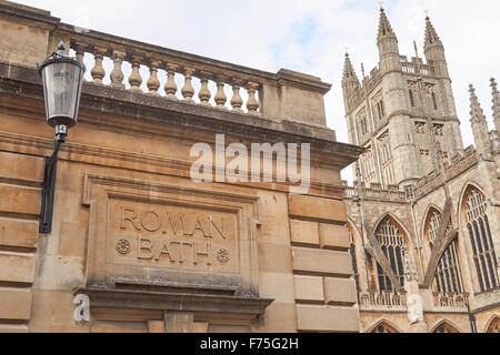 Stein gehauen Schild an die Roman Baths mit der Abteikirche von Bath im Hintergrund, Bath Somerset England Vereinigtes Königreich Großbritannien Stockfoto