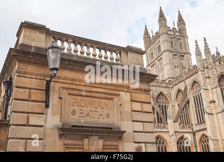 Stein gehauen Schild an die Roman Baths mit der Abteikirche von Bath im Hintergrund, Bath Somerset England Vereinigtes Königreich Großbritannien Stockfoto