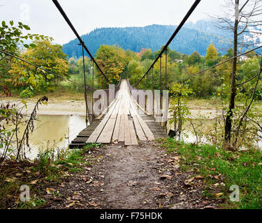 Federung, die Hängebrücke über Bergfluss Stockfoto