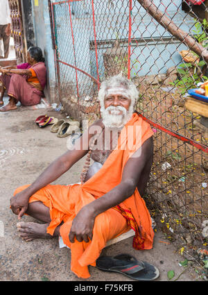 Alte Mann Anhänger gekleidet tragen Safranrobe sitzen vor dem Kapaleeswarar Tempel, einen Hindu-Tempel von Shiva, Mylapore, Chennai, Tamil Nadu, Indien Stockfoto