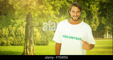 Zusammengesetztes Bild des lächelnden Mann zeigte auf seine ehrenamtliche tshirt Stockfoto