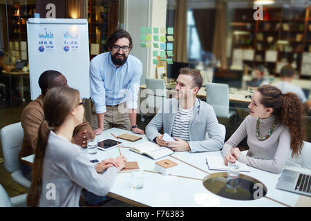 Glücklich modernen Büroangestellten, die Pläne und Ideen der Tagung diskutieren Stockfoto