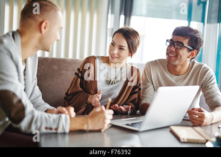 Gruppe von Menschen, die Pläne in ungezwungener Atmosphäre zu besprechen Stockfoto