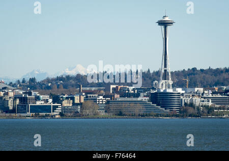 Seattle, Washington, USA. 21. November 2015. Seattle Space Needle, Seattle Center liegt an Bord einer Washington State Ferry in dieser Ansicht, Blick nach Osten über den Gewässern der Elliott Bay im Puget Sound entnehmen. Die Space Needle, bei über 605 Fuß hoch, wurde vom Hotelier Edward E. Carlson und Architekten John Graham Jr. entworfen und gebaut von Auftragnehmer Howard S. Wright für die 1962 Welten Fair. Errichtet um 200 mph Winden und ein 9.1 Erdbeben zu widerstehen, die Space Needle verfügt über eine Aussichtsplattform und ein Drehrestaurant. Glacier Peak, sehen im Osten in der Cascade Mountain Range Stockfoto