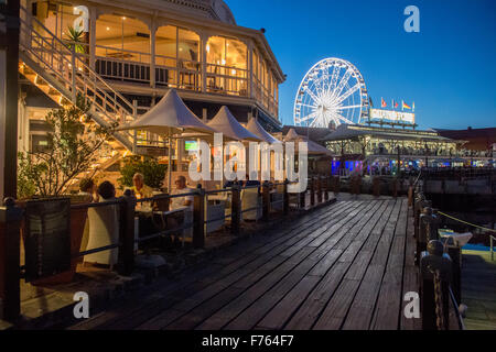 Menschen Essen in einem Restaurant im Freien am Abend bei V und A Waterfront, Innenstadt von Kapstadt, Südafrika Stockfoto