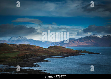 Gewitterwolken über den Sound of Sleat, Isle Of Skye, mit Schnee bedeckt Gipfeln des Festlands Schottland im Hintergrund. Stockfoto