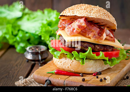 Big Sandwich - Hamburger Burger mit Rindfleisch, Käse, Tomaten und gebratenem Speck Stockfoto