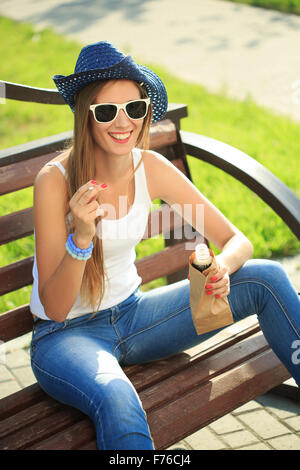 Mädchen aus einer Papiertüte auf der Straße trinken. raucht. Cowboy-Hut Stockfoto