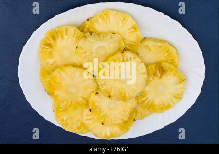 Ananas in einer Platte auf einem blauen Hintergrund Stockfoto