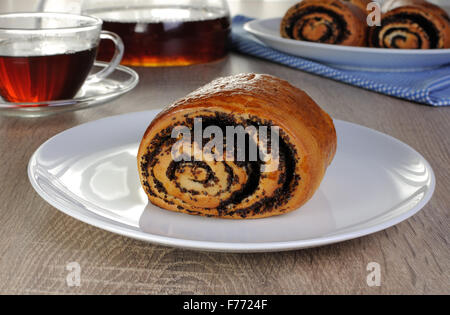 Frisch gebackene Brötchen mit Mohn auf einem Teller Stockfoto