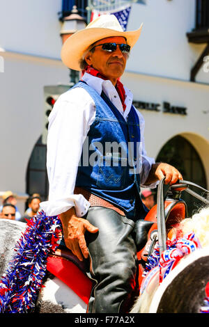 Cowboy reitet hinunter State Street auf seinem Pferd am 4. Juli in Santa Barbara, Kalifornien Stockfoto