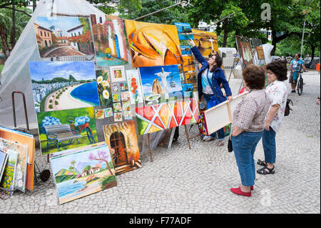 RIO DE JANEIRO, Brasilien - 25. Oktober 2015: Shopper Blick auf Kunst angezeigt auf dem fairen Hippie-Markt im allgemeinen Osorio, Ipanema. Stockfoto