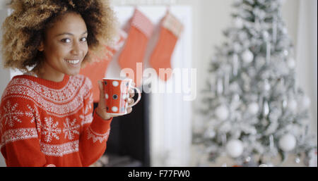 Lächelnde Frau trinkt eine Tasse Kaffee Weihnachten Stockfoto