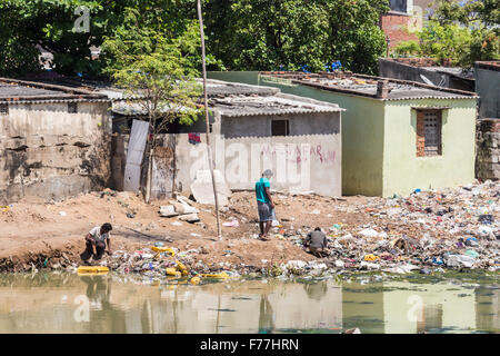 Armut in der Dritten Welt Lifestyle: die lokale Bevölkerung in Slums sichten Müll an den Ufern des verschmutzten Adyar Flussmündung in Chennai, Tamil Nadu, Indien Stockfoto