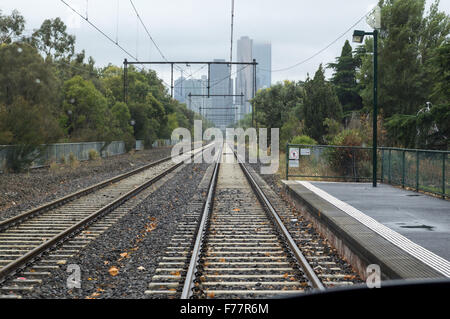 Blick von Graham Street Station entlang der Melbourne Straßenbahnen in Richtung Innenstadt von Melbourne, Victoria, Australien, an einem regnerischen, nebligen Tag verfolgt. Stockfoto