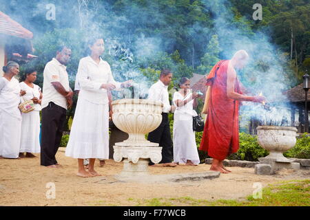 Sri Lanka, Kandy - Mönch Leuchten Angebote der Weihrauch im Tempel des Zahns, Sri Dalada Maligawa, UNESCO-Weltkulturerbe Stockfoto