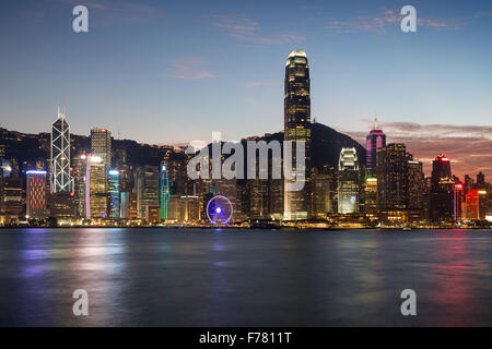 Malerische Aussicht auf die Skyline von Hong Kong Island am Abend über Victoria Harbour mit beleuchteten städtischen Hochhäusern in Hongkong, China. Stockfoto