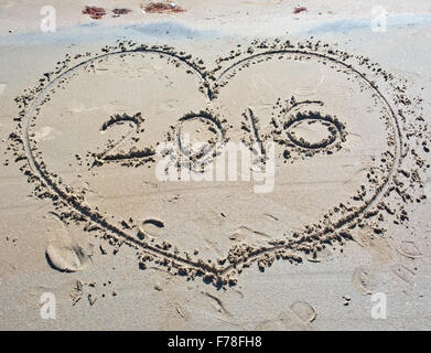 Herz im Sand mit dem leeren Raum am Strand in der Mitte und chaotisch geschrieben druckt herum. Stockfoto