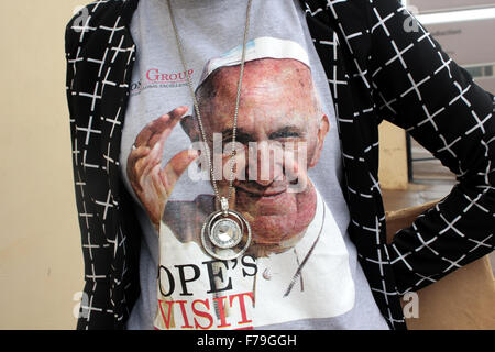 Kampala, Uganda. 27. November 2015. Eine Frau zieht gerne Souvenir T-shirt mit einem Willkommens-Nachricht für Papst Francis in der ugandischen Hauptstadt Kampala. Die Papst wird voraussichtlich Uganda am 27-29. November während einer Afrika-Reise besuchen, die Kenia und der Zentralafrikanischen Republik zu bedecken. Bildnachweis: Samson Opus/Alamy Live-Nachrichten Stockfoto