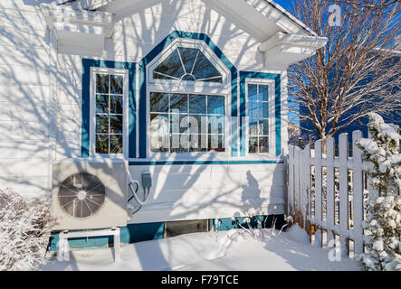 Wärmepumpe-Einheit an der Seite eines Hauses im Winter. Stockfoto