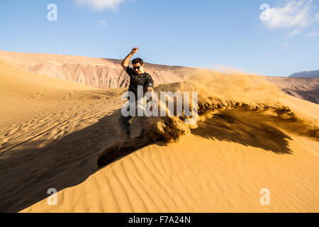 Sandboarding in Cerro Dragon, in der Atacama-Wüste. Iquique, Tarapaca Region, Chile. Stockfoto