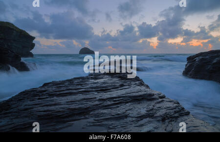 Die untergehende Sonne über Trebarwith Strand an der Nordküste Cornwalls Stockfoto