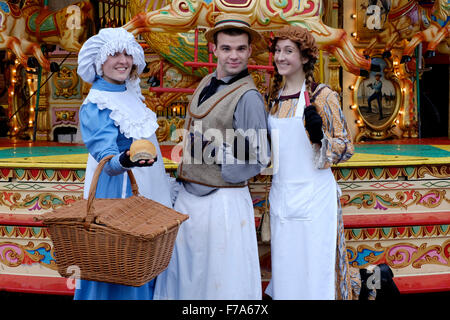 drei Darsteller in Kostümen vor einer traditionellen Karussell auf dem viktorianischen Festival von Weihnachten 2015 Portsmouth England uk Stockfoto