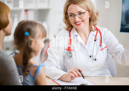 Hausarzt, Beratung, Mutter und Kind hält Röntgenbild Stockfoto