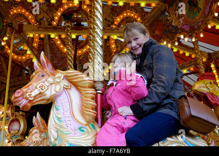 Frau und Kind reiten eine traditionelle Karussell auf dem viktorianischen Festival von Weihnachten 2015 Portsmouth England uk Stockfoto