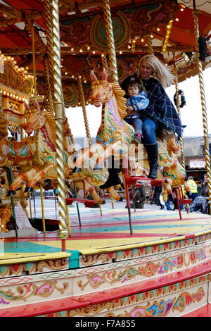 Frau und Kind reiten traditionelle Karussell auf dem viktorianischen Festival von Weihnachten 2015 Portsmouth England uk Stockfoto