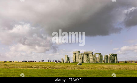 Stonehenge, prähistorische Monument gesetzt gegen die Gruppen von Besuchern und einem sonnigen blauen Himmel. Stockfoto