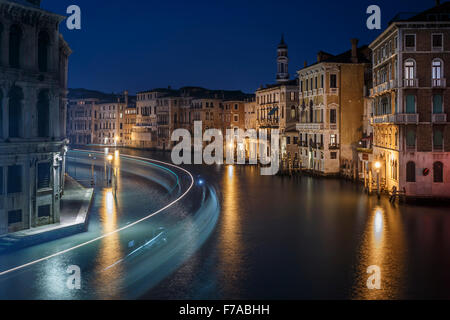 Der Canal Grande in der Nacht mit den Lichtspuren ein Vaporetto (Wasserbus), Blick vom Rialto Bridge, Venedig, Italien. Stockfoto