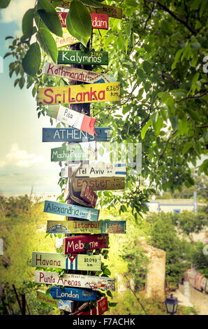Lustige Richtungen Wegweiser mit Abstand zu vielen verschiedenen Ländern, Städten und Orten Stockfoto