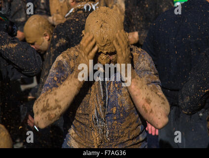 Iranische Schiiten muslimischer Mann bedeckt im Schlamm Weinen während Ashura Tag, Provinz Kurdistan, Bidjar, Iran Stockfoto