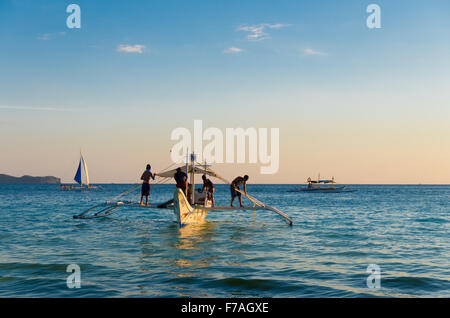 BORACAY, Philippinen - 17. Mai 2015: Traditionelle philippinische Boote kurz vor Sonnenuntergang auf der Insel Boracay, die meisten touristischen desti Stockfoto