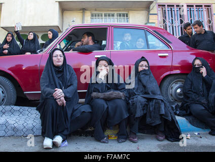 Iranische Schiiten muslimische Frauen und Männer, die gerade die Ashura-Parade innen ein rotes Auto, den Tag des Todes von Imam Hussein, Kurdistan Provinz, Bidjar, Iran Stockfoto