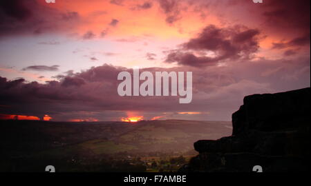Die Sonne geht auf einen Sturm beladen Himmel über Curbar Rand in der Peak District National Park, Derbyshire England UK Stockfoto