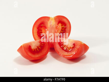 Tomaten und zwei Quartale vor einem weißen Hintergrund Stockfoto