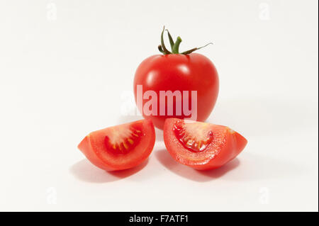 Tomaten und zwei Quartalen gegen eine weiße bckground Stockfoto